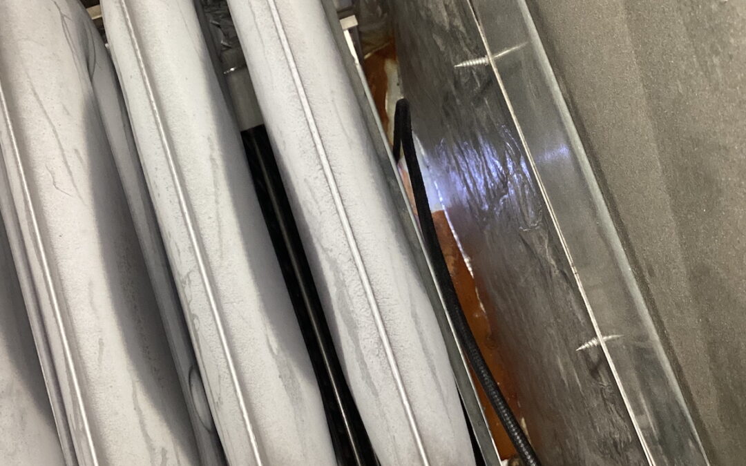 Interior view of a heat exchanger with rusty elements. A borescope light shines from the bottom of the case, highlighting the areas where the hazardous damage was located.