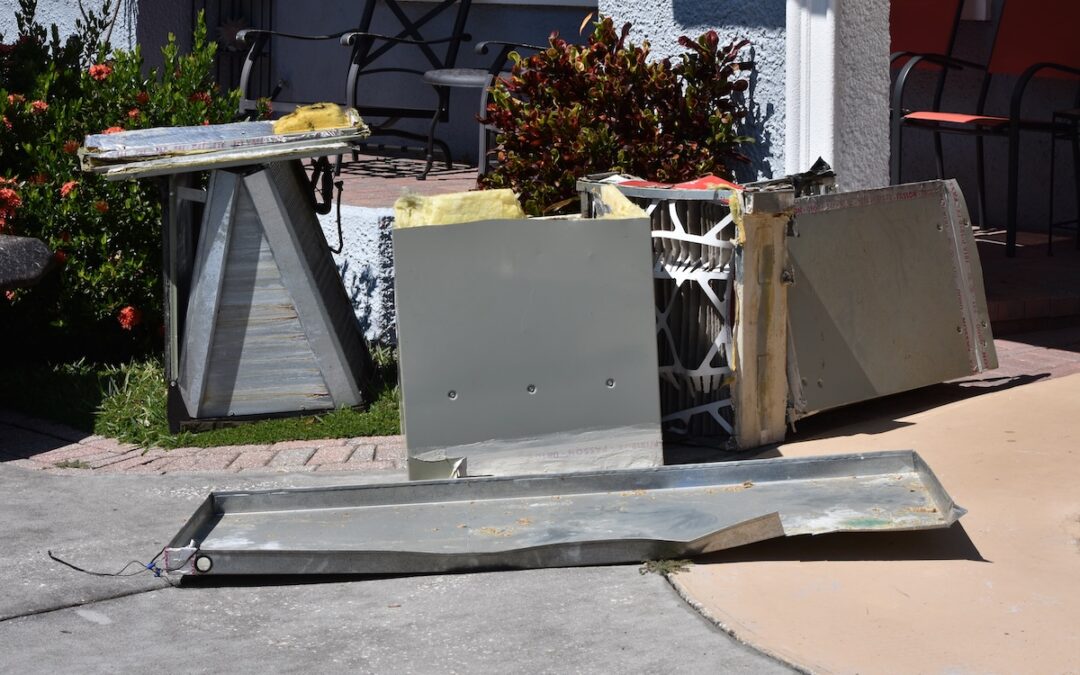 Discarded parts of a replaced furnace sit outside a residence